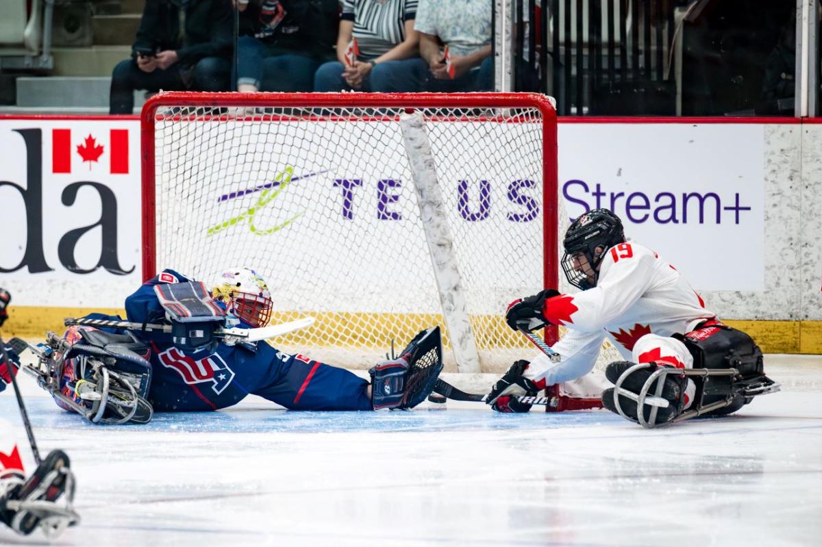 A Canadian Para ice hockey player scoring a goal against USA goaltender